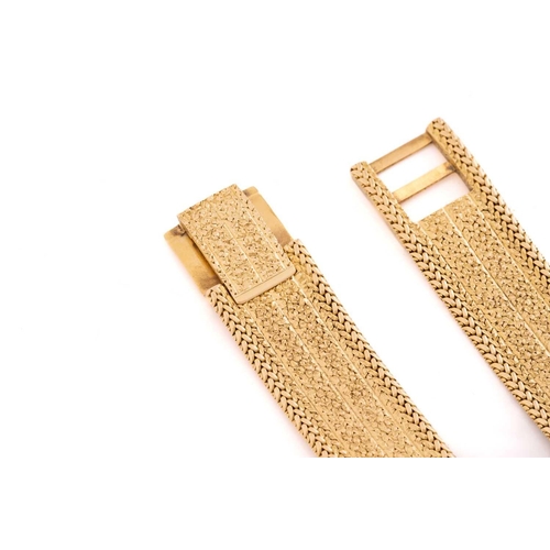 288A - An 18mm woven yellow metal strap stamped '750' with a folding clasp with an over-length of 15.5cm. T... 