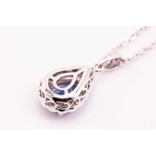 34 - A tanzanite and diamond cluster pendant on chain, featuring a pear-shaped tanzanite of 8.3 x 5.6 mm,... 