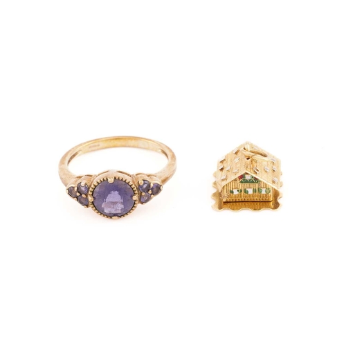 40 - A 9ct yellow gold and purple gemstone ring, the round chequerboard-faceted central stone flanked wit... 