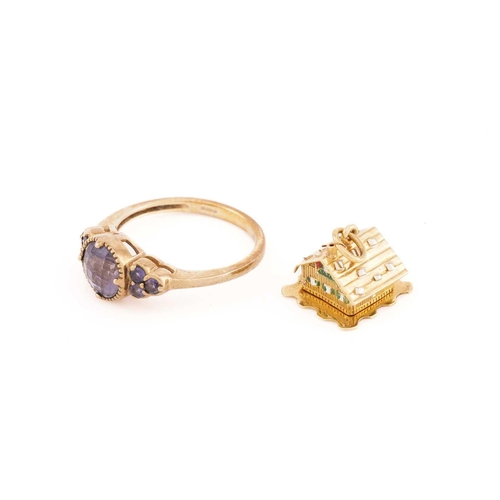 40 - A 9ct yellow gold and purple gemstone ring, the round chequerboard-faceted central stone flanked wit... 