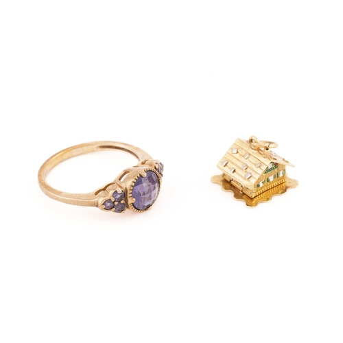 40 - A 9ct yellow gold and purple gemstone ring, the round chequerboard-faceted central stone flanked wit... 