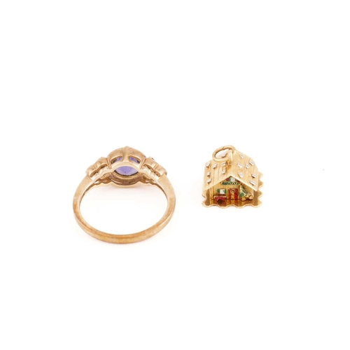 40 - A 9ct yellow gold and purple gemstone ring, the round chequerboard-faceted central stone flanked wit... 