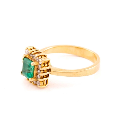 43 - An emerald and diamond entourage ring, centred with an emerald-cut emerald in bright green colour, a... 