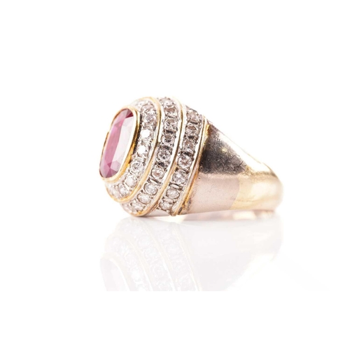 54 - A ruby and diamond dress ring, containing an oval faceted ruby in dark purplish-red colour, approxim... 