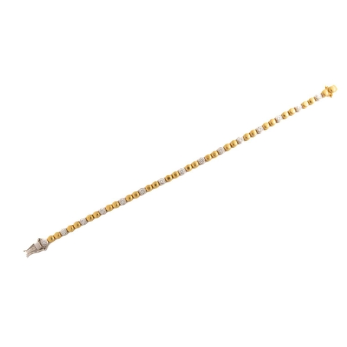 58 - A two-toned line bracelet set with diamonds, each link with a grooved decorated edge and alternating... 