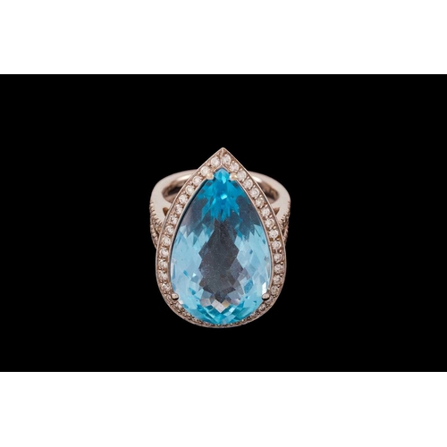 61 - A topaz and diamond halo ring, consisting of a large pear-shaped sky blue topaz, approximately measu... 