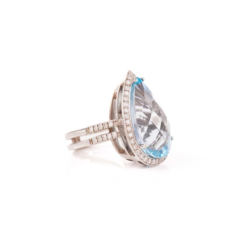 61 - A topaz and diamond halo ring, consisting of a large pear-shaped sky blue topaz, approximately measu... 