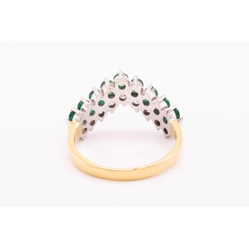 63 - An emerald and diamond ring in 18ct gold, of chevron design, comprising a row of nine brilliant-cut ... 