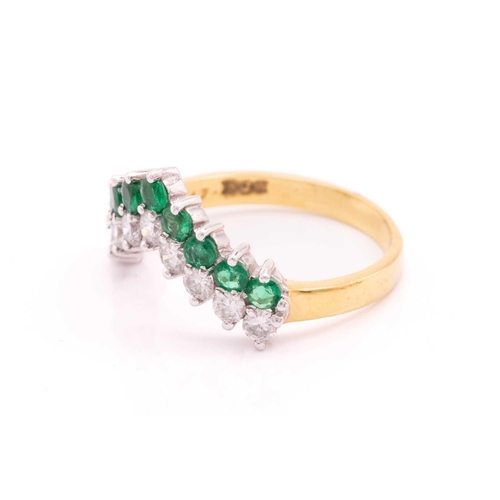 63 - An emerald and diamond ring in 18ct gold, of chevron design, comprising a row of nine brilliant-cut ... 