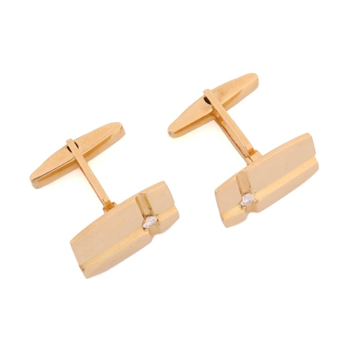 64 - A pair of cufflinks with diamond accents, each comprising a rectangular panel with curved sides, wit... 