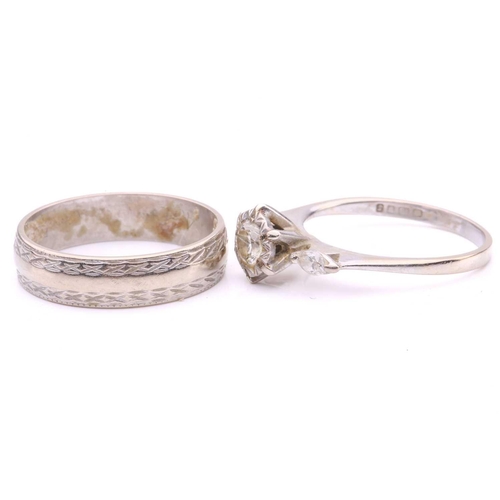 77 - A three-stone diamond ring and a wedding band en-suite in 18ct white gold; the first ring comprises ... 