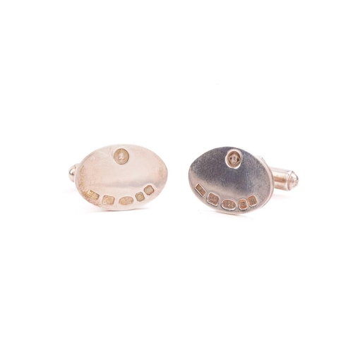 82 - Two pairs of silver cufflinks; the pair of oval cufflinks with feature marks on the panel, are fitte... 