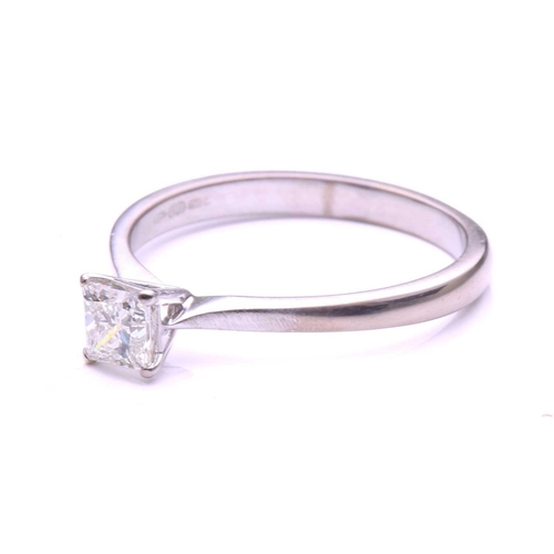 97 - A single stone diamond ring; the princess cut diamond in four claw mount to a plain 18-carat white g... 