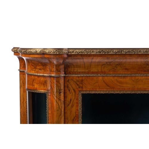 119 - A Victorian figured walnut credenza with a tulipwood banded figured top above a central glazed door ... 