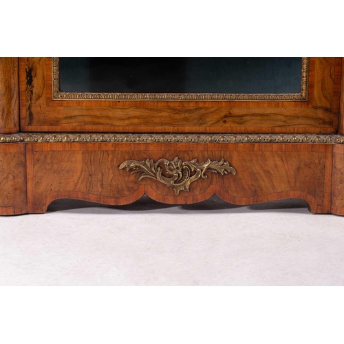 119 - A Victorian figured walnut credenza with a tulipwood banded figured top above a central glazed door ... 