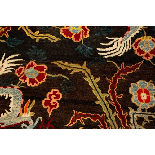 156 - A black ground Tibetan pictorial rug, late decorated with a battling dragon and phoenix an early 20t... 