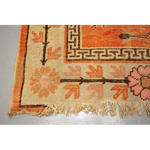 157 - A rust red ground Yarkand pictorial carpet, Kashgar, late 19th century, with desert flowers and deco... 