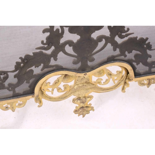 173 - A Louis XVI-style heavy ormolu spark guard, late 20th century, with a shaped arch top above a pieced... 