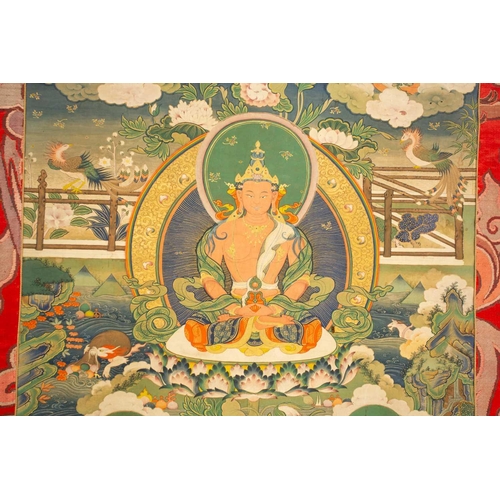 99 - A Tibetan Thangka of Amitayus, early 20th century, seated within a gilt sunburst halo, with deities,... 