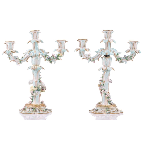 244 - A pair of German porcelain figural three sconce candelabra, with tre stum stems mounted with a brigh... 