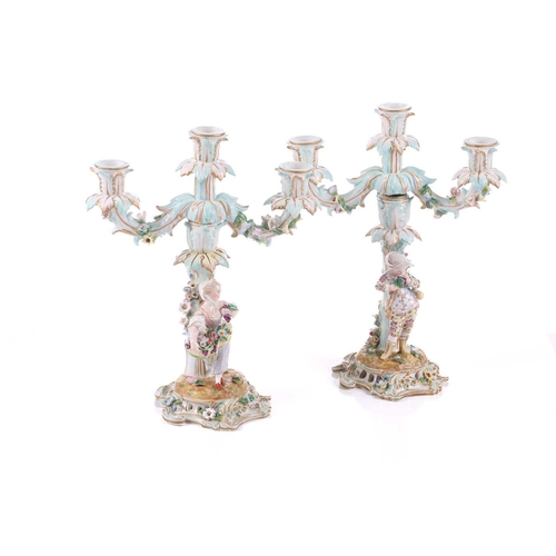 244 - A pair of German porcelain figural three sconce candelabra, with tre stum stems mounted with a brigh... 