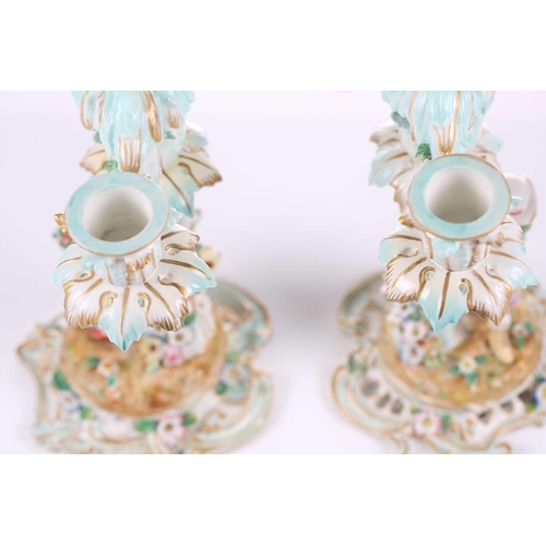 244 - A pair of German porcelain figural three sconce candelabra, with tre stum stems mounted with a brigh... 