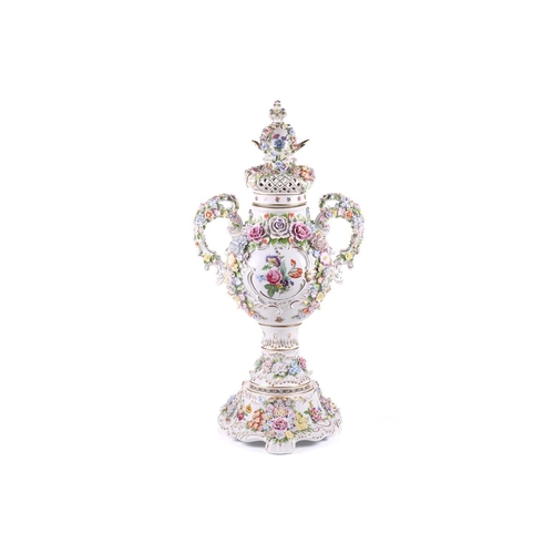 246 - A large German porcelain flower encrusted two handled trophy form urn and cover, 20th century, with ... 