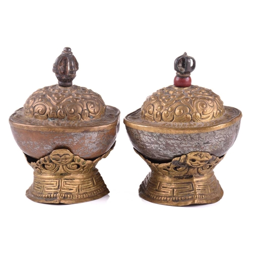 134 - A close pair of Tibetan kapala and stands, early 20th century, each with cast vajra knop above an em... 