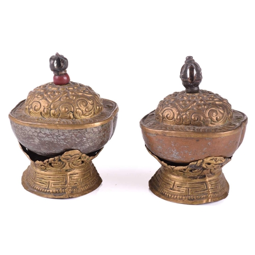 134 - A close pair of Tibetan kapala and stands, early 20th century, each with cast vajra knop above an em... 