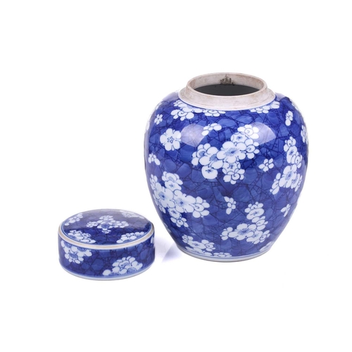 154 - A Chinese porcelain Kangxi style blue & white ginger jar and cover, with blossoming prunus on a crac... 