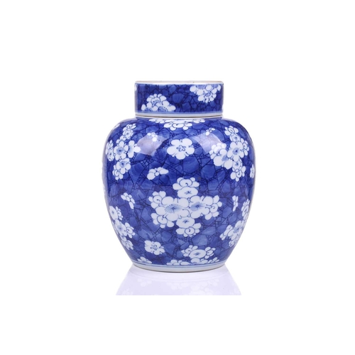 154 - A Chinese porcelain Kangxi style blue & white ginger jar and cover, with blossoming prunus on a crac... 