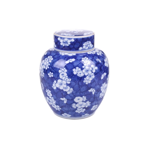 154 - A Chinese porcelain Kangxi style blue & white ginger jar and cover, with blossoming prunus on a crac... 