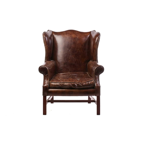 195 - A George III-style distressed hide upholstered gentleman's wingback armchair, 20th century, with mel... 