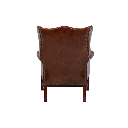 195 - A George III-style distressed hide upholstered gentleman's wingback armchair, 20th century, with mel... 