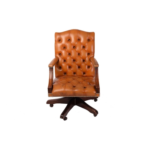 198 - A deep buttoned tan hide upholstered reproduction swivel office chair with moulded mahogany arm supp... 