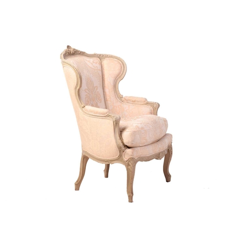 203 - A French Louis XV-style dove grey painted bergere armchair with wing back and carved shell cresting ... 