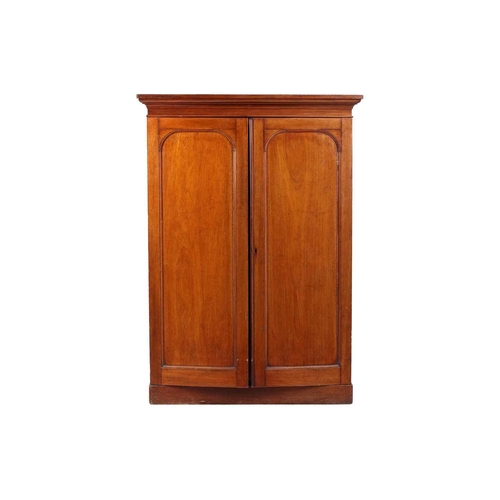 234 - An early Victorian mahogany housekeeper's cupboard, the pair of doors with arched panels opening to ... 