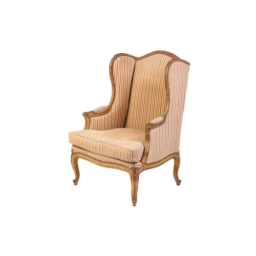 237 - A Louis XV style bergere wing chair, 19th century, with carved wood and gilt gesso frame and striped... 