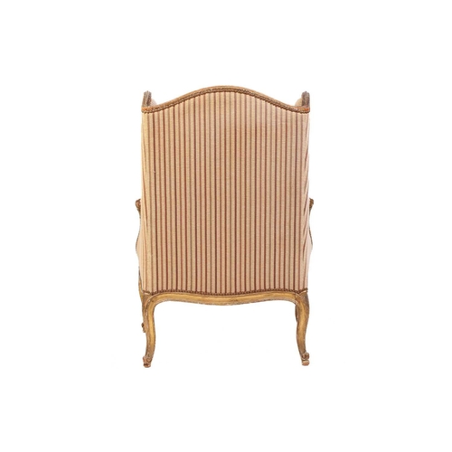 237 - A Louis XV style bergere wing chair, 19th century, with carved wood and gilt gesso frame and striped... 