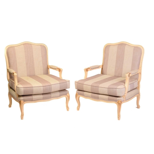 239 - A pair of Louis XV-style ivory painted and parcel gilt fauteuils with arched backs and broad seats a... 