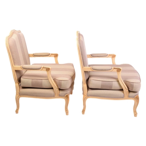 239 - A pair of Louis XV-style ivory painted and parcel gilt fauteuils with arched backs and broad seats a... 