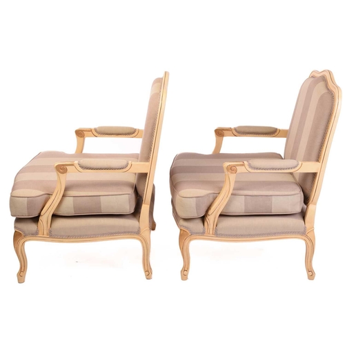 239 - A pair of Louis XV-style ivory painted and parcel gilt fauteuils with arched backs and broad seats a... 