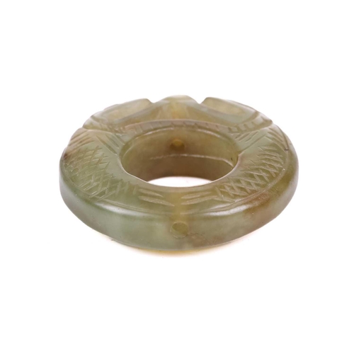 307 - A Chinese carved green/yellow jade pendant ring in the form of a pair of scaley pig dragons contesti... 