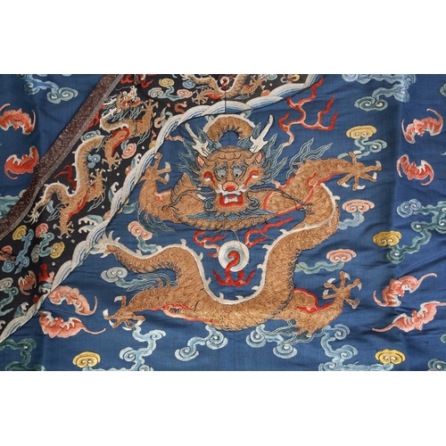 310 - A Chinese silk embroidered Dragon robe, Qing, worked with nine gilt thread dragons each chasing flam... 