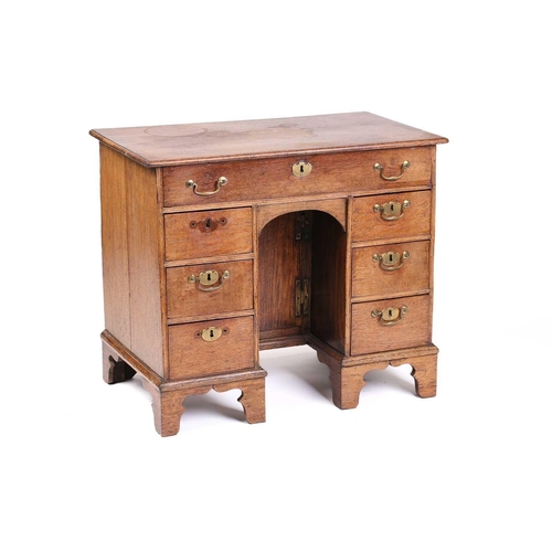 319 - An 18th-century oak kneehole writing desk fitted with a central frieze drawer above a further six sh... 