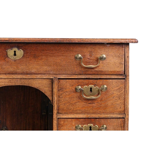 319 - An 18th-century oak kneehole writing desk fitted with a central frieze drawer above a further six sh... 