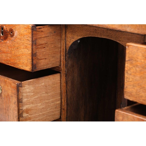 319 - An 18th-century oak kneehole writing desk fitted with a central frieze drawer above a further six sh... 