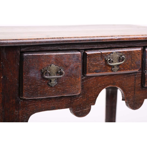 325 - An early 18th-century oak three-drawer side table with turned legs terminating in pad feet. 67 cm wi... 