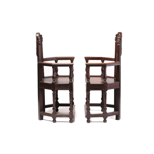 344 - A pair of French carved oak caquetoire armchairs, 19th/20th century, the curved backs carved and pie... 