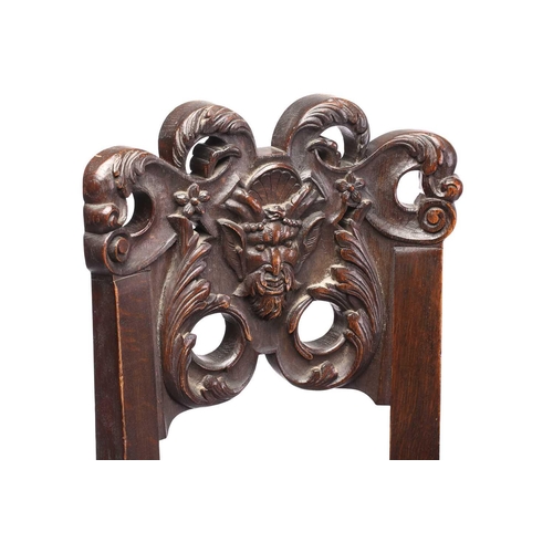 344 - A pair of French carved oak caquetoire armchairs, 19th/20th century, the curved backs carved and pie... 